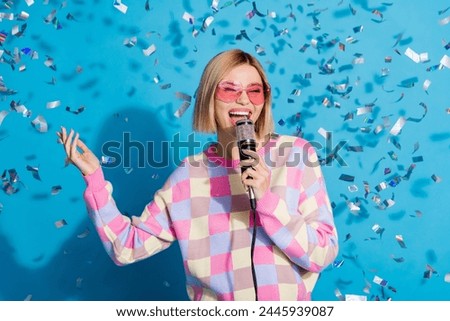 Photo portrait of pretty young girl sunglass celebrate party singing confetti wear trendy pink outfit isolated on blue color background
