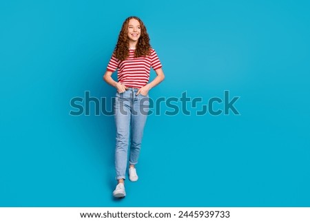 Full size photo of optimistic pretty girl wear stylish t-shirt denim trousers look at sale empty space isolated on blue color background