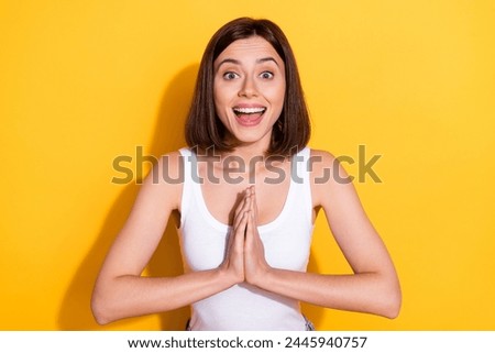 Photo of excited funky woman wear white singlet arms together asking buying new clothes isolated yellow color background