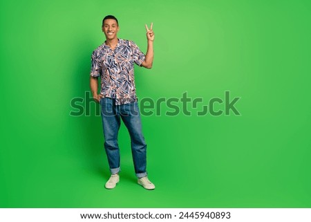 Full body photo of satisfied glad nice person demonstrate v-sign empty space isolated on green color background Royalty-Free Stock Photo #2445940893