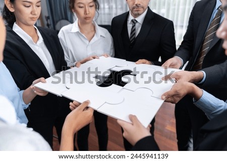 Multiethnic business people holding jigsaw pieces and merge them together as effective solution solving teamwork, shared vision and common goal combining diverse talent. Meticulous Royalty-Free Stock Photo #2445941139