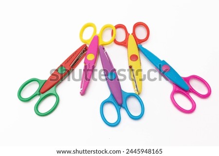 Set of vibrant craft scissors in various colors neatly arranged on a white surface