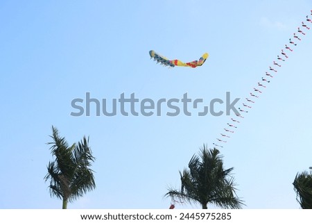 Colorful kite flying in the clear blue sky in sunny summer day at Mekong Delta Vietnam. Happy childhood moments.