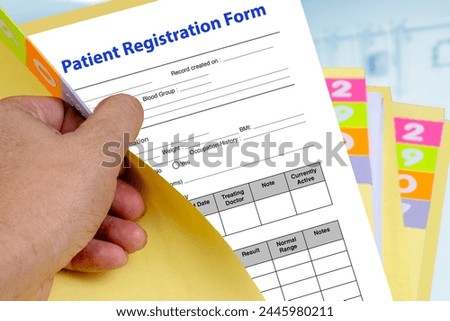 Hand open yellow medical record folder then revealing patient registration form. Royalty-Free Stock Photo #2445980211