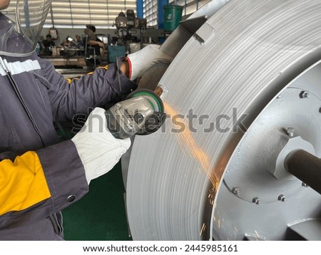 The man use grinder grinding fan blower impeller for balancing weight of impeller Royalty-Free Stock Photo #2445985161