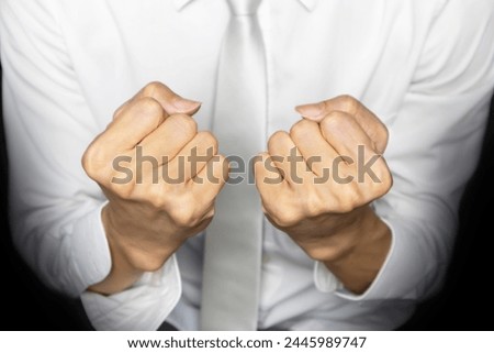 business man in white work clothes ,clenched fists to encourage work.,Build confidence in doing business