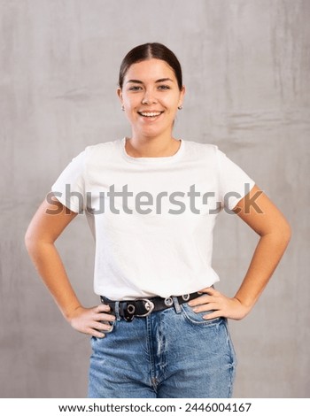 Positive smiling young woman in casual clothes posing indoors