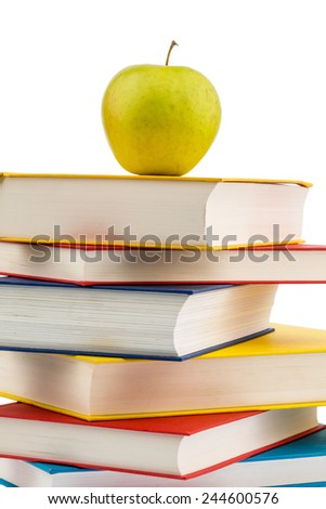 an apple lying on a pile of books. symbolic photo for healthy, vitamin-rich food in the school break.