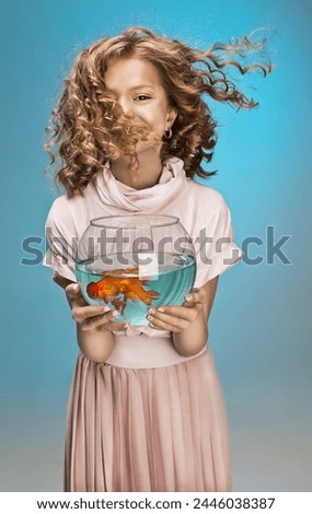 Portrait of young beautiful girl with curly hair with fish