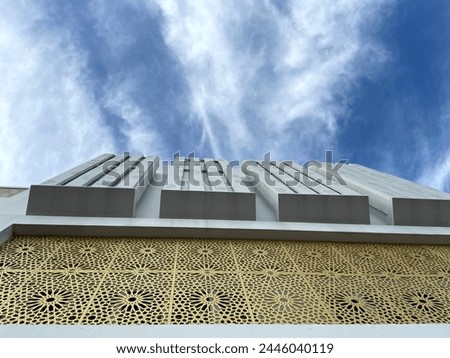 Building wall facade with unique motif against blue sky background
