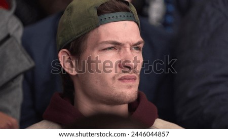 Guy nervously watch game close up attention spectator. People spectator fan watch game hockey closeup view excitedly looking match in crowd 4K. Hockey fan with serious face enter score game at stadium