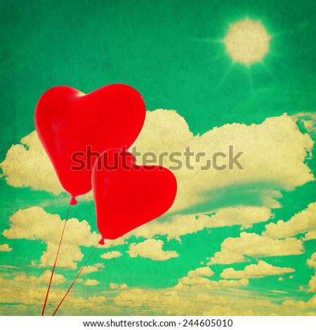 perfect blue sky with white clouds and red heart shaped balloons. vintage style toned picture