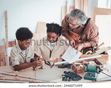Teenage African Americans learn woodworking Skills from Asian Elderly carpenters in a Workshop, Experienced master carpenter transferring knowledge to his younger colleagues