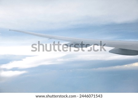 Exterior visual photo view from a plane aircraft with a wing through a window from flight to see clouds like sheep clouds on a blue space sky