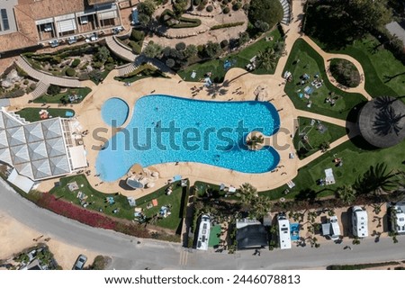 Aerial photo of the town of Benidorm in Spain showing a drone view of a camp site with many motorhomes and caravans on the camping site an a outdoor swimming pool with families on vacation having fun
