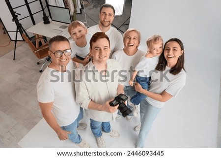 Male photographer with big family on photo shoot in studio