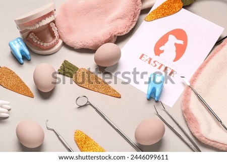 Composition with greeting card, dental tools, jaw model and Easter decor on beige background