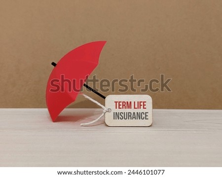

Wooden tag and red umbrella with the word Term Life Insurance. Concept of insurance coverage