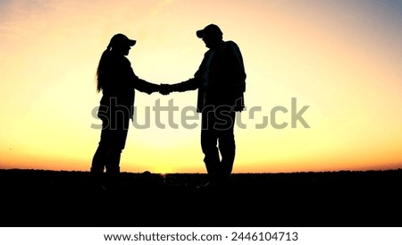 silhouette two farmers shaking hands sunset. agriculture concept. working people farm sunset. victory agreement sign. harvesting. harvest season. senior worker handshake. owner wheat field sunset.