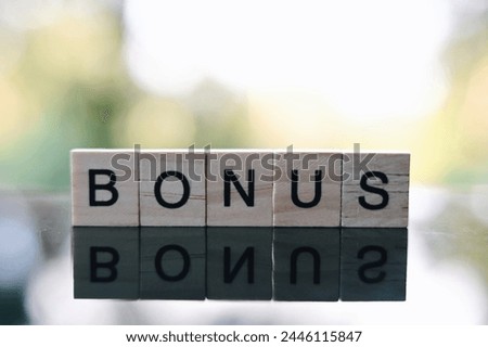 close up bonus wooden text block on table, saving and manage to success business concept