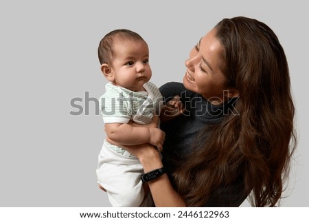 Happy mother emrasing with her newborn daughter, close-up portrait. Smiling woman with her infant baby. Family people and love concept