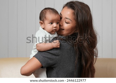 Happy mother emrasing with her newborn daughter, close-up portrait. Smiling woman with her infant baby. Family people and love concept