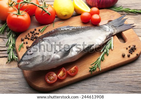 Fresh raw fish and food ingredients on table