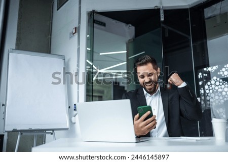 Overjoyed young Caucasian man have triumph have pleasant news on cell call. Happy male feel euphoric receive good message online. Royalty-Free Stock Photo #2446145897