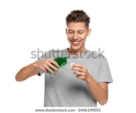 Young man with mouthwash on white background Royalty-Free Stock Photo #2446149051
