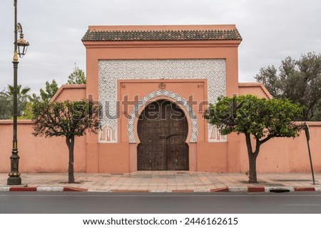 Wooden door in Marrakesh, Morocco. Moroccan closed archway gate in stone terracotta wall with islamic ornaments
