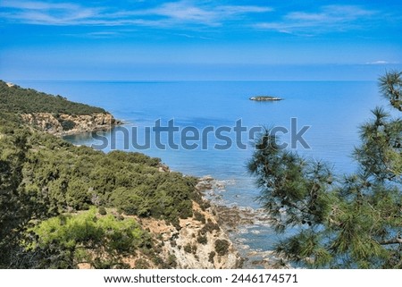 Steep, forested cliffs and the azure blue Mediterranean on the North Coast of Akamas Peninsula, Paphos district, Cyprus. In the distance St George's Island (Kakoskali).
 Royalty-Free Stock Photo #2446174571