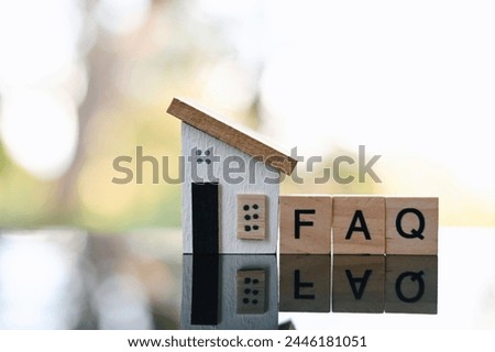 close up FAQ wooden text block and toy wooden house on wood table, Frequently Asked Questions