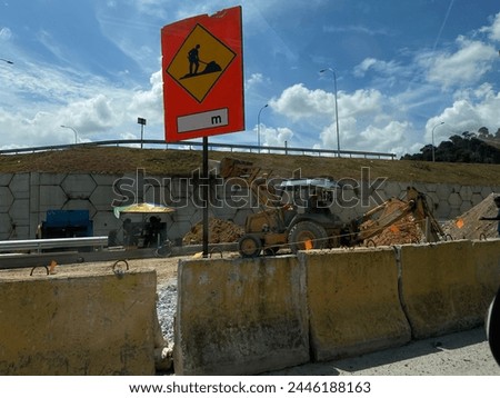 A construction sign sitting on the side of a road