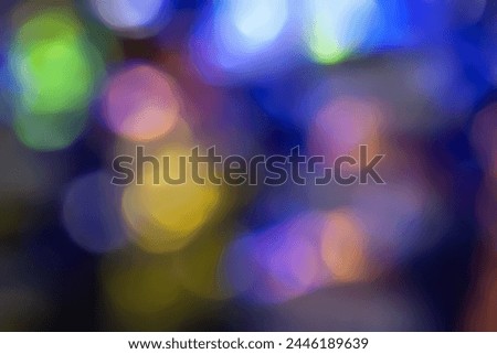 Defocused neon glow. Overlaying highlights. Colorful bokeh. Futuristic LED lighting. Blur of colors on dark abstract background
