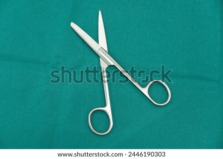 Surgical scissors on green surgery wrap set.Medical instrument in the operating room.