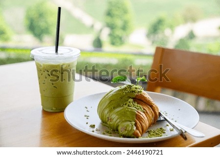 Matcha green tea with croissant on the wooden table at Choui Fong tea plantation in Chiang Rai province, Thailand Royalty-Free Stock Photo #2446190721