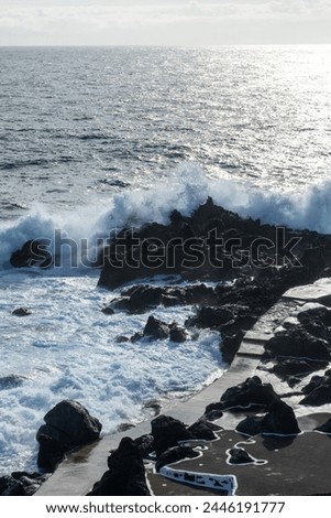 Powerful waves crash along the shoreline of Cinco Ribeiras, a scenic bathing area on Terceira Island, Azores. Royalty-Free Stock Photo #2446191777