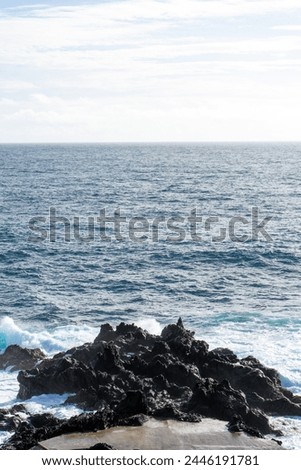 Powerful waves crash along the shoreline of Cinco Ribeiras, a scenic bathing area on Terceira Island, Azores. Royalty-Free Stock Photo #2446191781