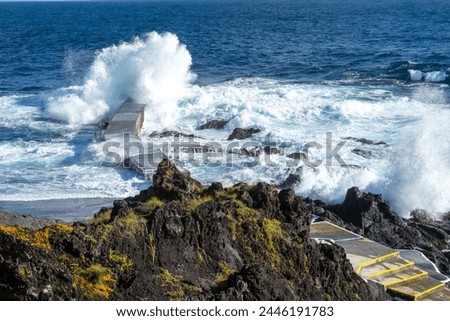Powerful waves crash along the shoreline of Cinco Ribeiras, a scenic bathing area on Terceira Island, Azores. Royalty-Free Stock Photo #2446191783