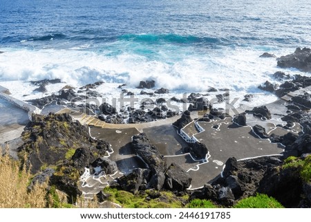 Powerful waves crash along the shoreline of Cinco Ribeiras, a scenic bathing area on Terceira Island, Azores. Royalty-Free Stock Photo #2446191785