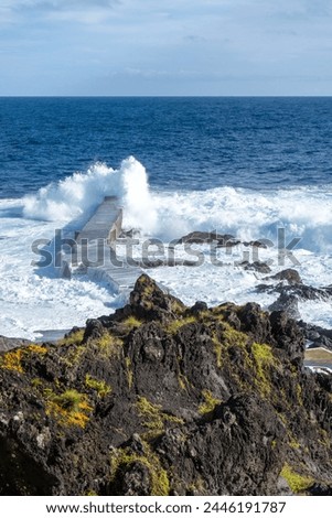 Powerful waves crash along the shoreline of Cinco Ribeiras, a scenic bathing area on Terceira Island, Azores. Royalty-Free Stock Photo #2446191787