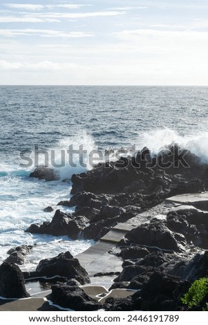 Powerful waves crash along the shoreline of Cinco Ribeiras, a scenic bathing area on Terceira Island, Azores. Royalty-Free Stock Photo #2446191789