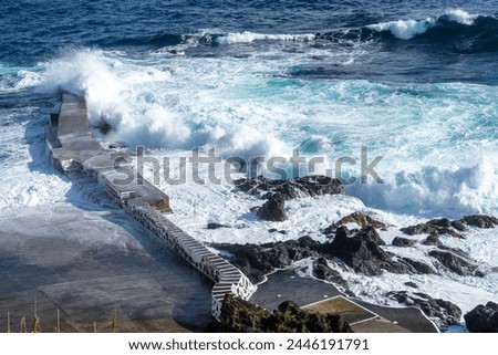 Powerful waves crash along the shoreline of Cinco Ribeiras, a scenic bathing area on Terceira Island, Azores. Royalty-Free Stock Photo #2446191791