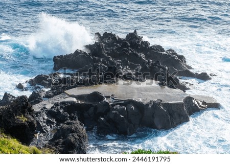 Powerful waves crash along the shoreline of Cinco Ribeiras, a scenic bathing area on Terceira Island, Azores. Royalty-Free Stock Photo #2446191795
