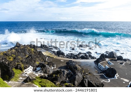 Powerful waves crash along the shoreline of Cinco Ribeiras, a scenic bathing area on Terceira Island, Azores. Royalty-Free Stock Photo #2446191801