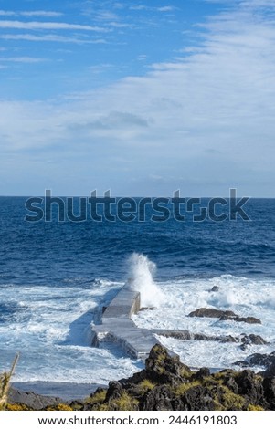 Powerful waves crash along the shoreline of Cinco Ribeiras, a scenic bathing area on Terceira Island, Azores. Royalty-Free Stock Photo #2446191803