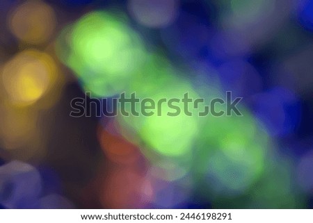 Defocused neon glow. Overlay of light highlights. Colored bokeh. Futuristic LED illumination. Blur of colors on dark abstract background