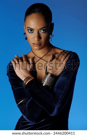 A young African American model stands with crossed arms in a poised pose for a portrait.