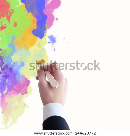 Young businessman painting a wall