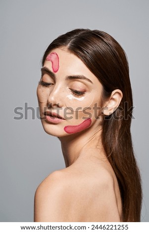 A young Caucasian woman with brunette hair adorned with patches, showcasing skin transformation in a studio setting.